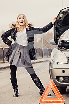 Woman, broken car and auto triangle on road