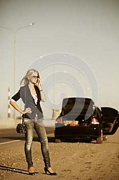 Woman with broken car calling on the phone