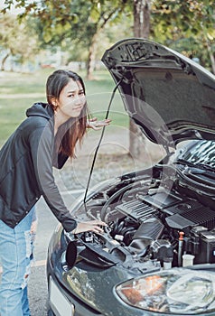 A woman with a broken car and she open bonnet