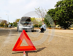 A woman with a broken car, waits for assistance