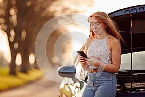 Woman With Broken Down Car On Country Road Calling For Help On Mobile Phone