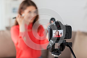 Woman with bronzer and camera recording video