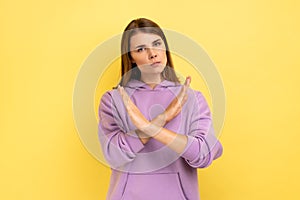 Woman with brown hair showing x sign with hands, there is no way more, hopelessness.