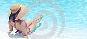 Woman with brown hat relaxing in swimming pool with blue water in sun , holiday concept