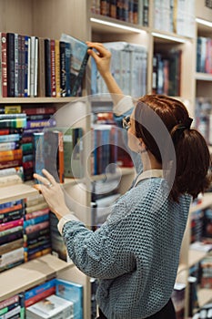 Woman browsing books in a cozy library setting