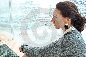 Woman, brunette, in a business setting, with a book in her hands. Public place, library