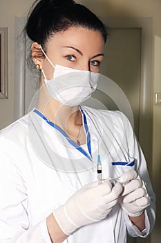 Woman brunette doctor with surgical glowes with syringe