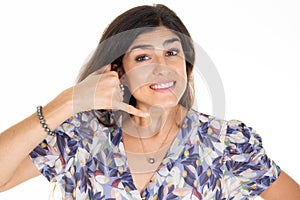 Woman brunette make phone gesture call me back with hand and fingers like talking on phone cell  on white background