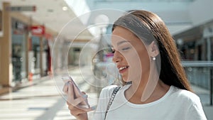 Woman brunette with phone smiling, close up. Young business woman professional happy. Beautiful multiethnic brunette