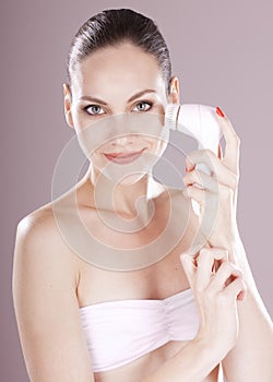 Woman with brush for deep cleansing facial.