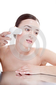 Woman with brush for deep cleansing facial.