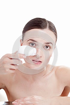 Woman with brush for deep cleansing facial.