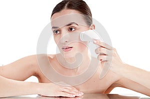 Woman with brush for deep cleansing facial.