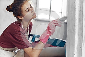 woman with brush in hands paint inside home interior renovation
