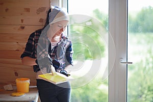 Woman with brush repair in a wooden house