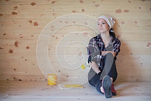 Woman with brush repair in a wooden house