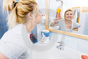 Woman brushing cleaning teeth in bathroom