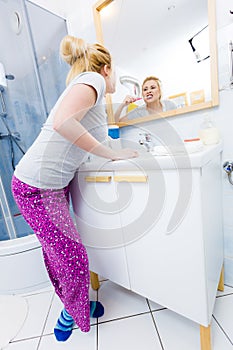 Woman brushing cleaning teeth in bathroom