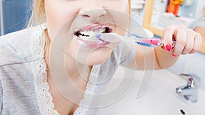 Woman brushing cleaning teeth in bathroom