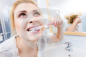 Woman brushing cleaning teeth in bathroom