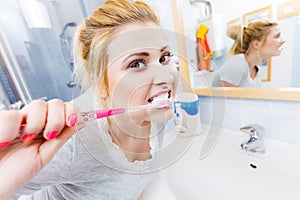 Woman brushing cleaning teeth in bathroom