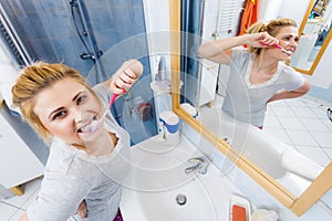 Woman brushing cleaning teeth in bathroom