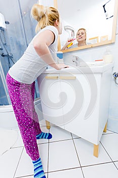 Woman brushing cleaning teeth in bathroom