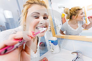 Woman brushing cleaning teeth in bathroom