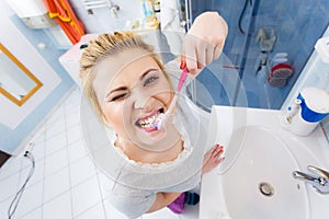 Woman brushing cleaning teeth in bathroom