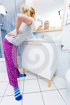 Woman brushing cleaning teeth in bathroom