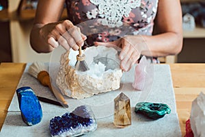 Woman brushing and dusting various gemstones