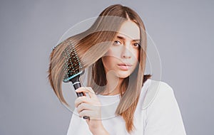 Woman brushing straight natural hair with comb. Girl combing hair with hairbrush. Hair care beauty concept. Brushing