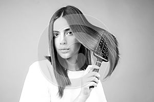 Woman brushing straight natural hair with comb. Girl combing hair with hairbrush. Hair care beauty concept. Brushing