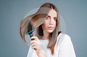 Woman brushing straight natural hair with comb. Girl combing hair with hairbrush. Hair care beauty concept. Brushing