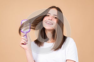 Woman brushing straight natural hair with comb. Girl combing healthy hair with hairbrush. Hair care beauty concept