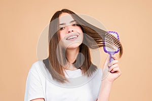 Woman brushing straight natural hair with comb. Girl combing healthy hair with hairbrush. Hair care beauty concept