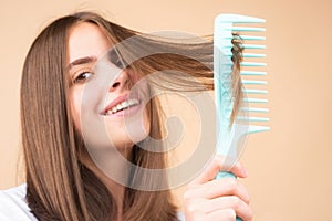 Woman brushing straight natural hair with comb. Girl combing long healthy hair with hairbrush. Hair care beauty concept