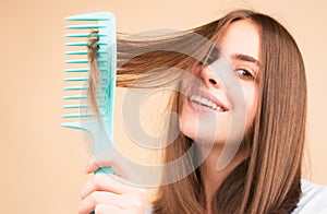 Woman brushing straight natural hair with comb. Girl combing long healthy hair with hairbrush. Hair care beauty concept