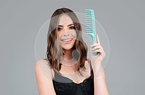 Woman brushing straight natural hair with comb. Girl combing long healthy hair with hairbrush. Hair care beauty concept