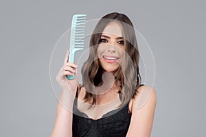 Woman brushing straight natural hair with comb. Girl combing long healthy hair with hairbrush. Hair care beauty concept