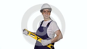 Woman builder in blue overalls and white hard hat helmet with level dance.