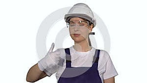 Woman builder in blue overalls and white hard hat helmet shows thumbs up.