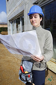 woman builder checking plan outdoors