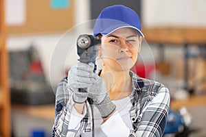 woman builder with drill in workshop