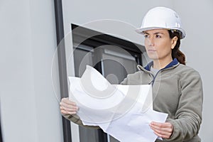 woman builder engineer looking at blueprint paper