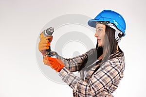 A woman builder in a hard hat on a white background with a drill in her hands. Combat gender stereotyping photo