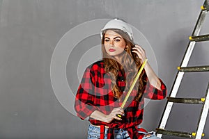 Woman builder holds tape measure