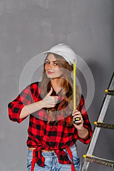 Woman builder holds tape measure