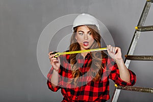 Woman builder holds tape measure