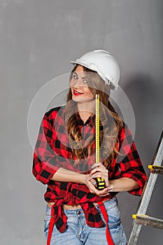 Woman builder holds tape measure